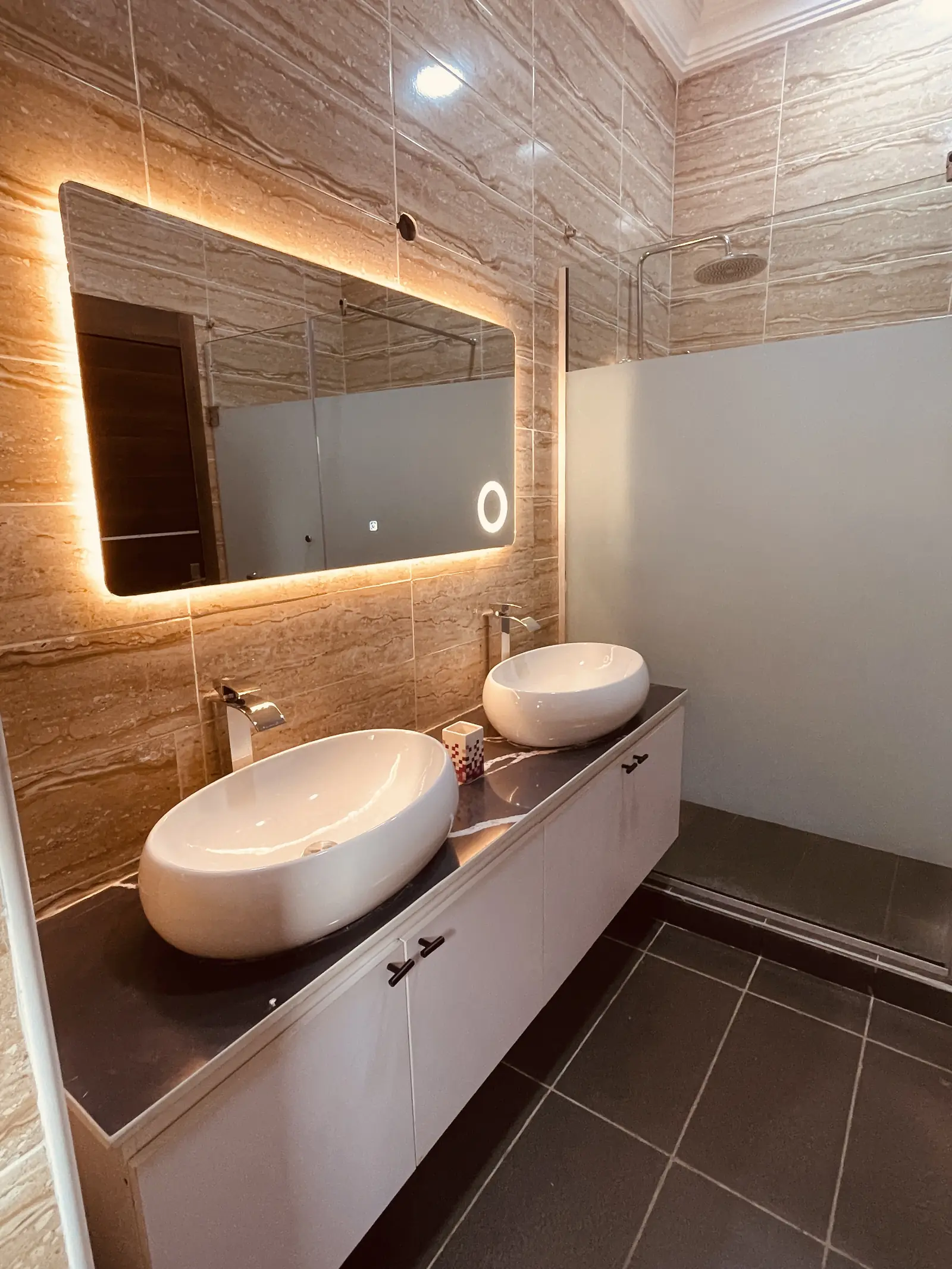 Master en-suite with twin basins and a lit mirror